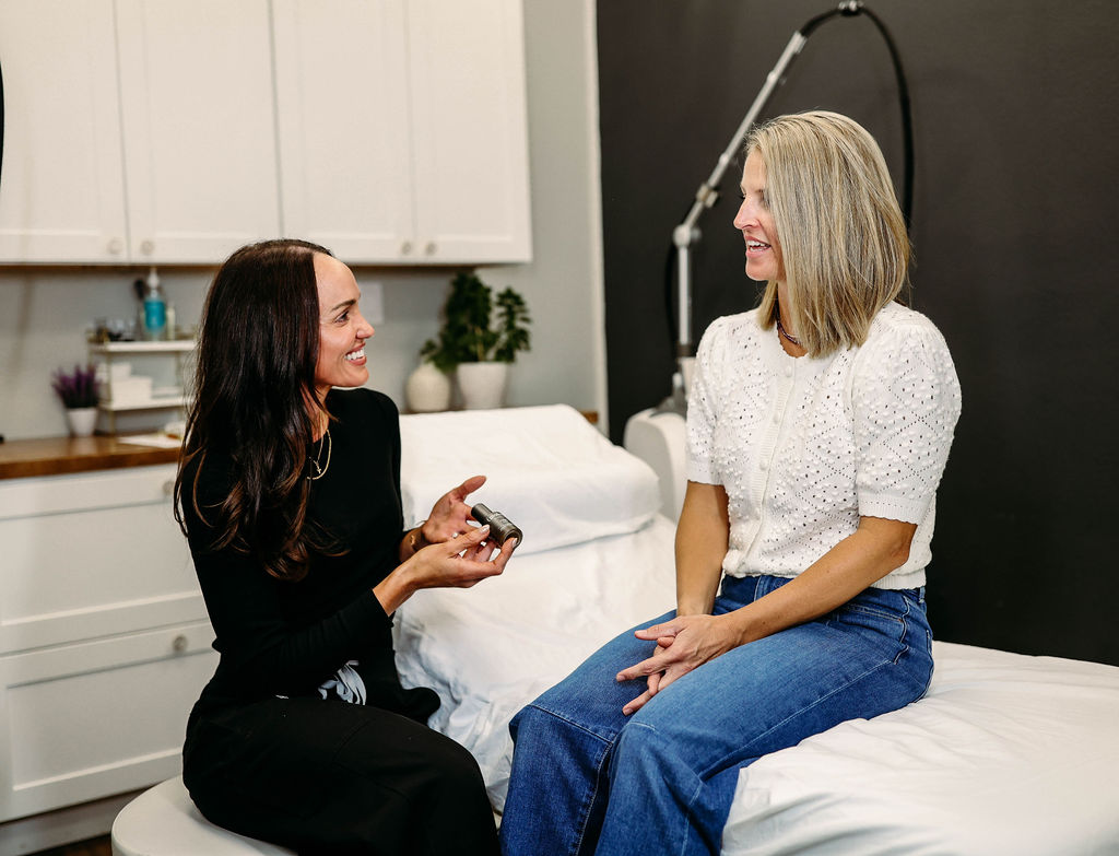 Aesthetic specialist discussing skincare treatment options with a client during a consultation inside the clinic.